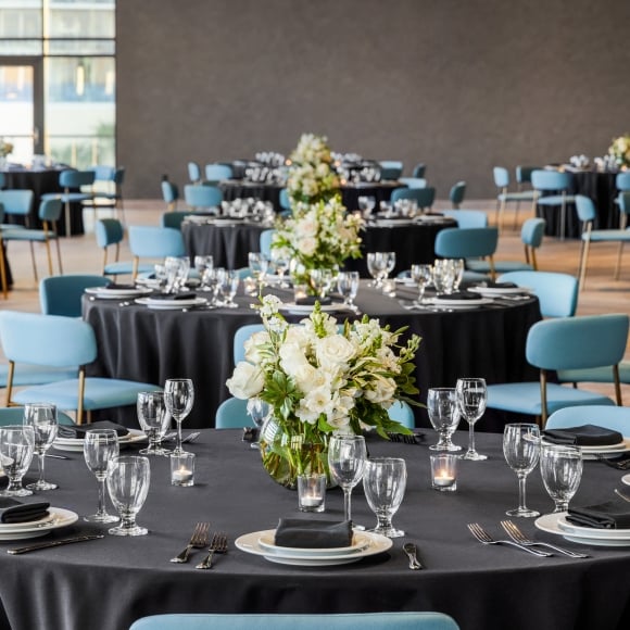 Seaside Vista ballroom set up in rounds for a wedding dinner with beautiful white flower centerpieces