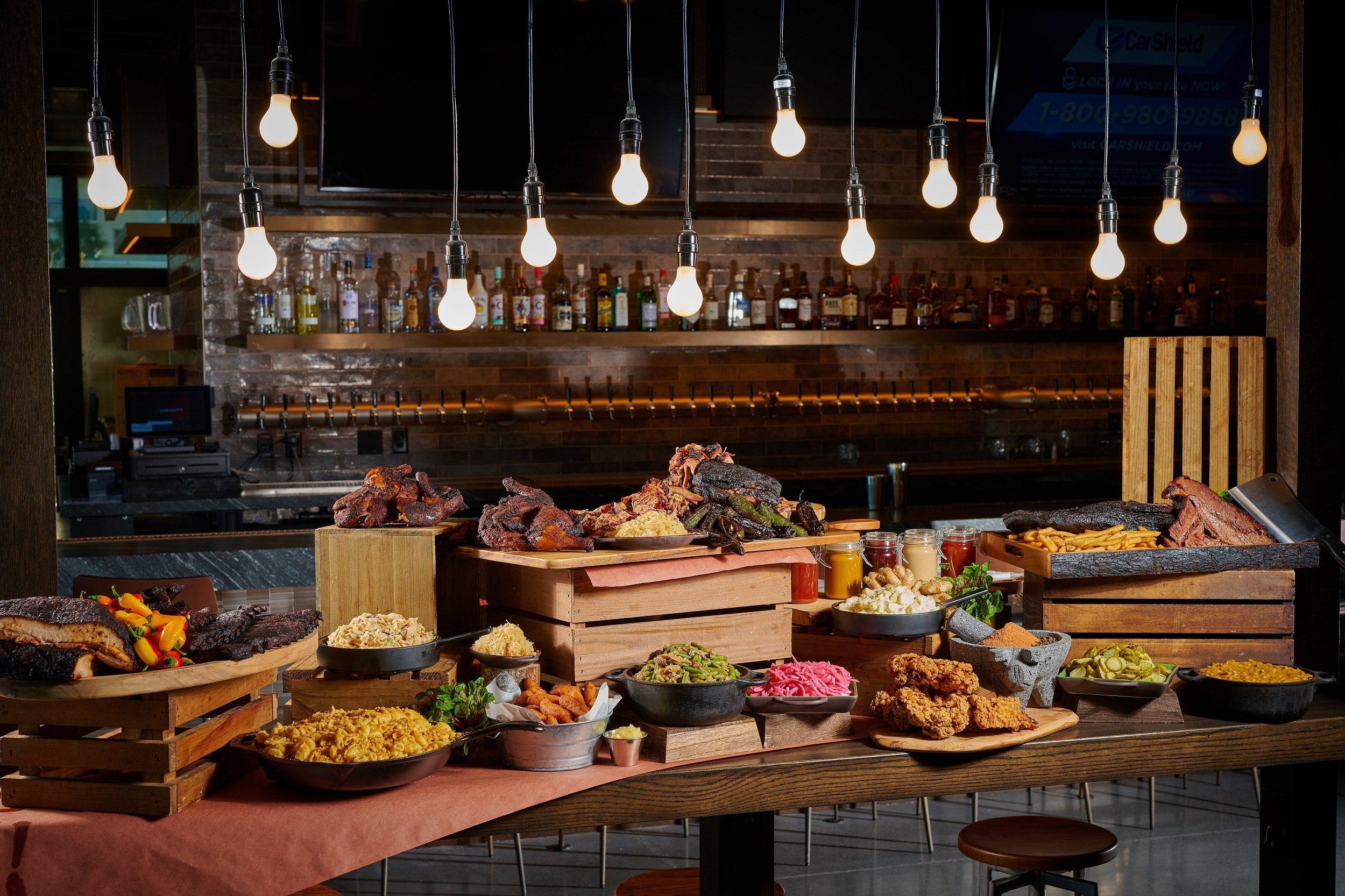 Black Drum Brewing spread of food including smoked meats, and all sides sitting in front of the bar