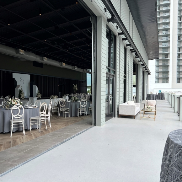 Seaside Vista wedding set up with rounds inside for dinner and the terrace set up for cocktail hour or side conversations